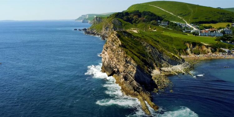 Aerial drone view of the Jurassic Coast in Dorset, England, showing dramatic cliffs, blue sea and coastline – UNESCO World Heritage Site